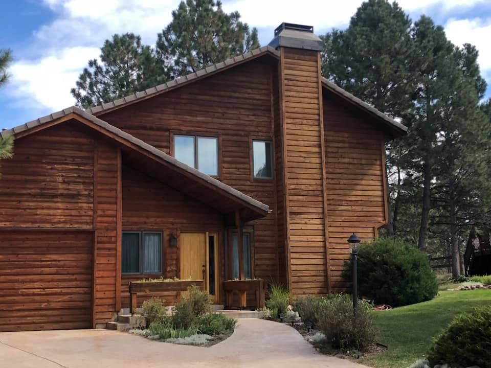 A large wooden house with a driveway leading to it