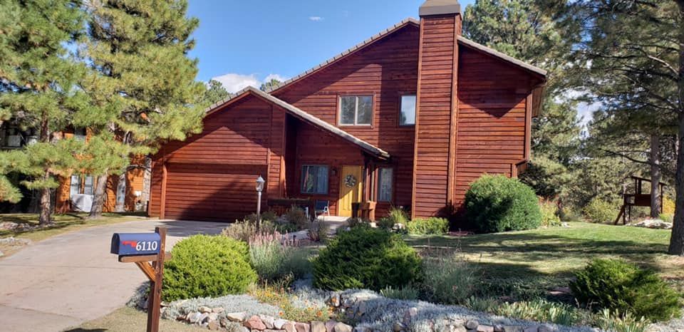 A large wooden house with a mailbox in front of it.
