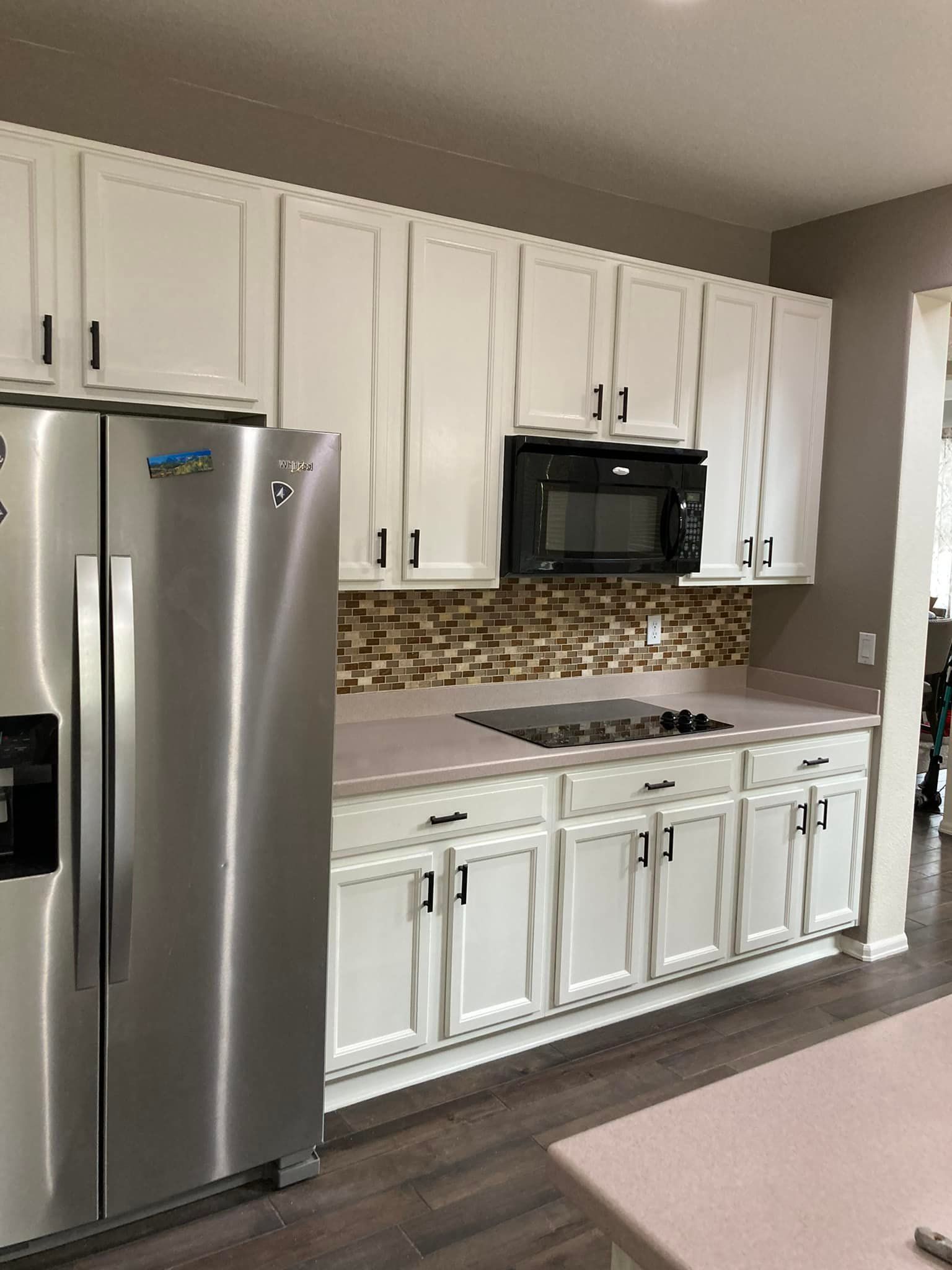 A kitchen with stainless steel appliances and white cabinets.
