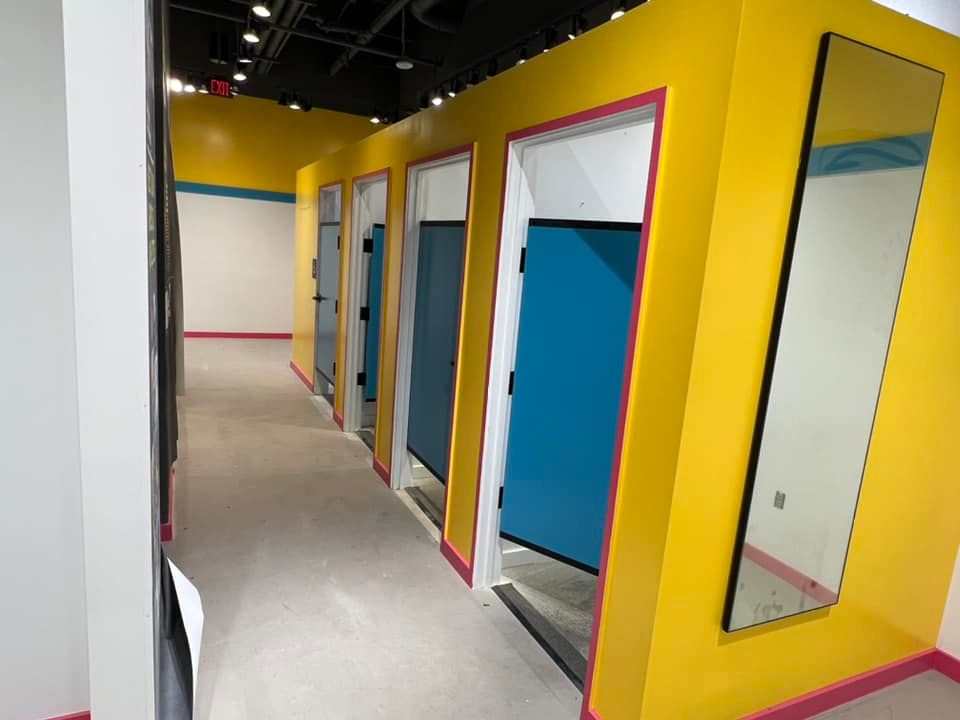 A hallway with yellow walls and blue doors