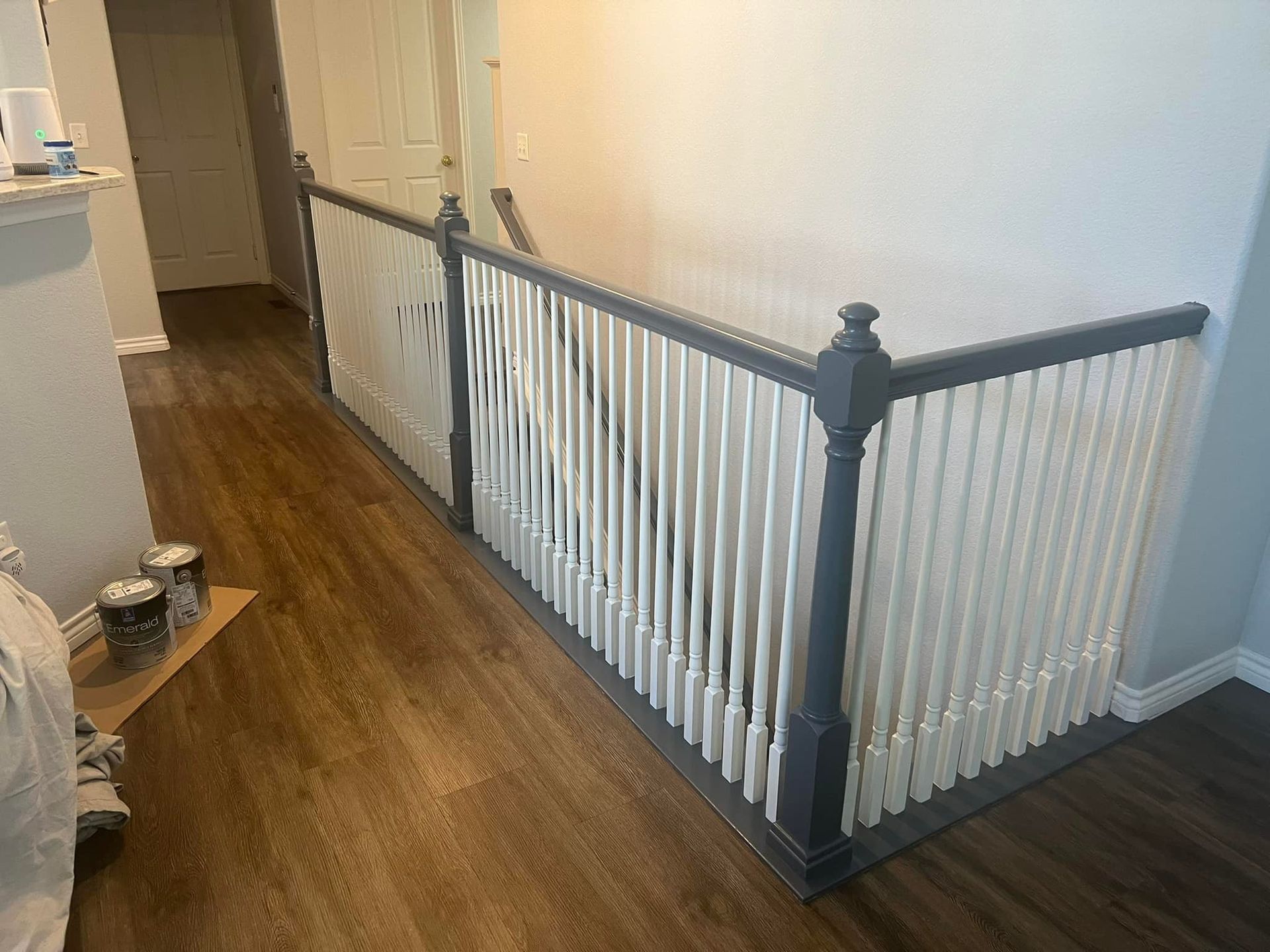 A staircase with a gray railing and a white railing in a hallway.