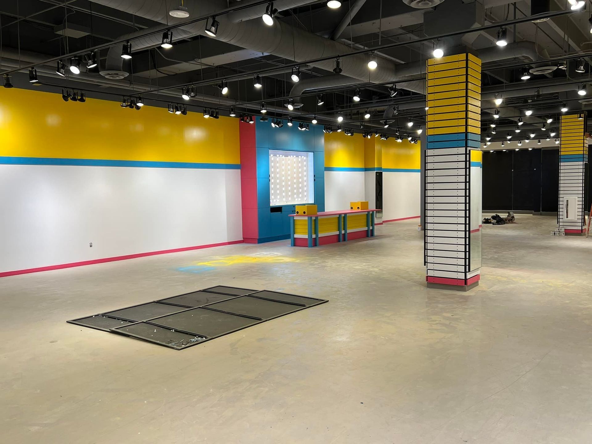A large empty room with colorful walls and columns.