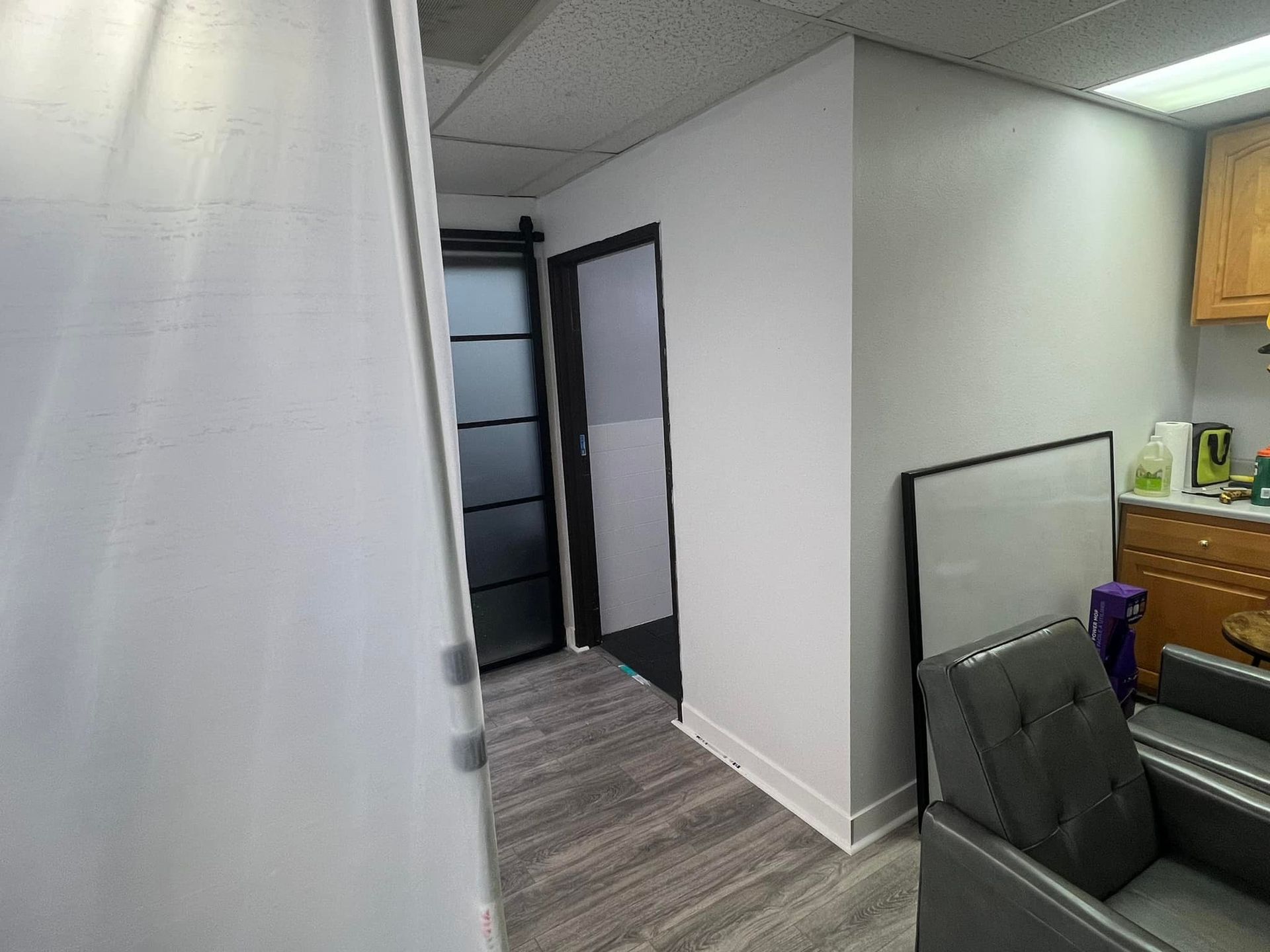 A hallway with a chair and a door in a room.