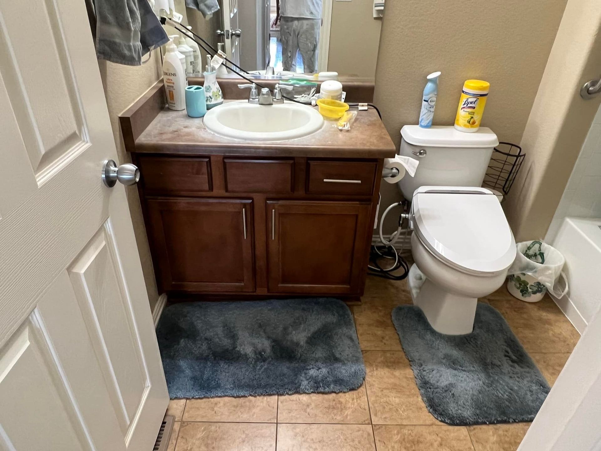A bathroom with a toilet , sink , and mirror.