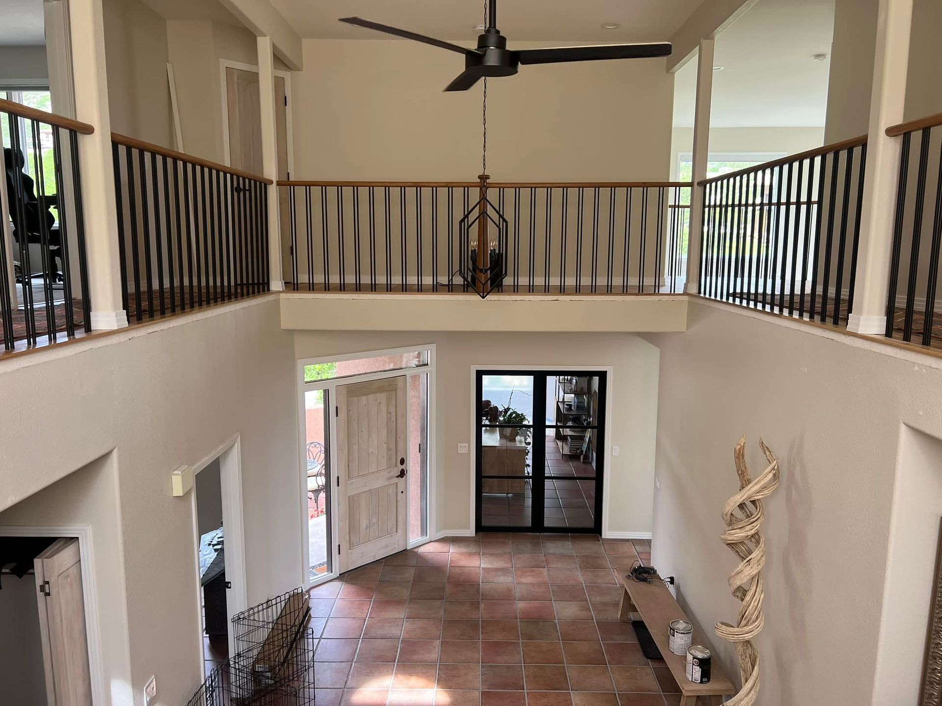 A large room with a balcony and a ceiling fan.