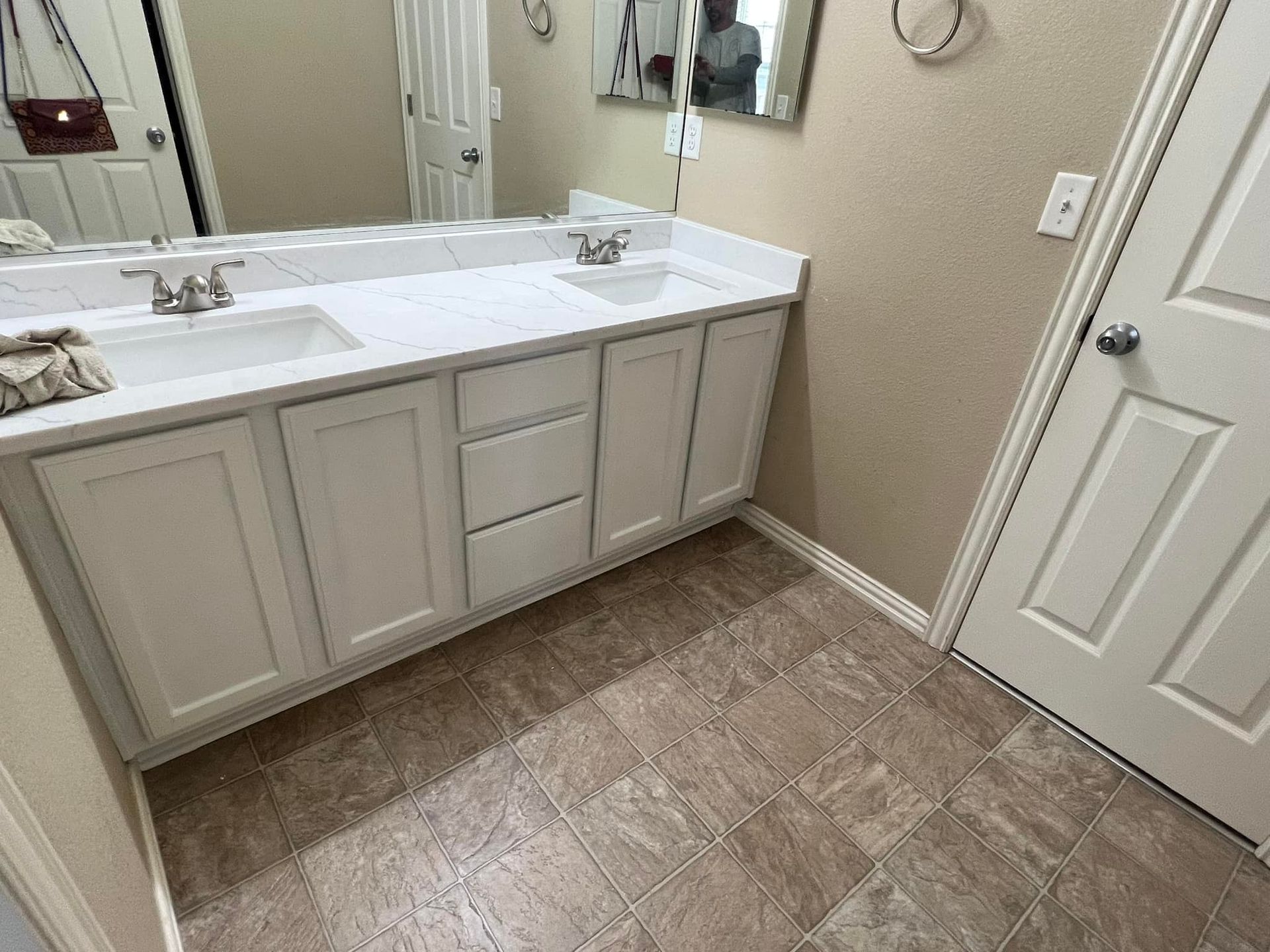 A bathroom with two sinks and a mirror.