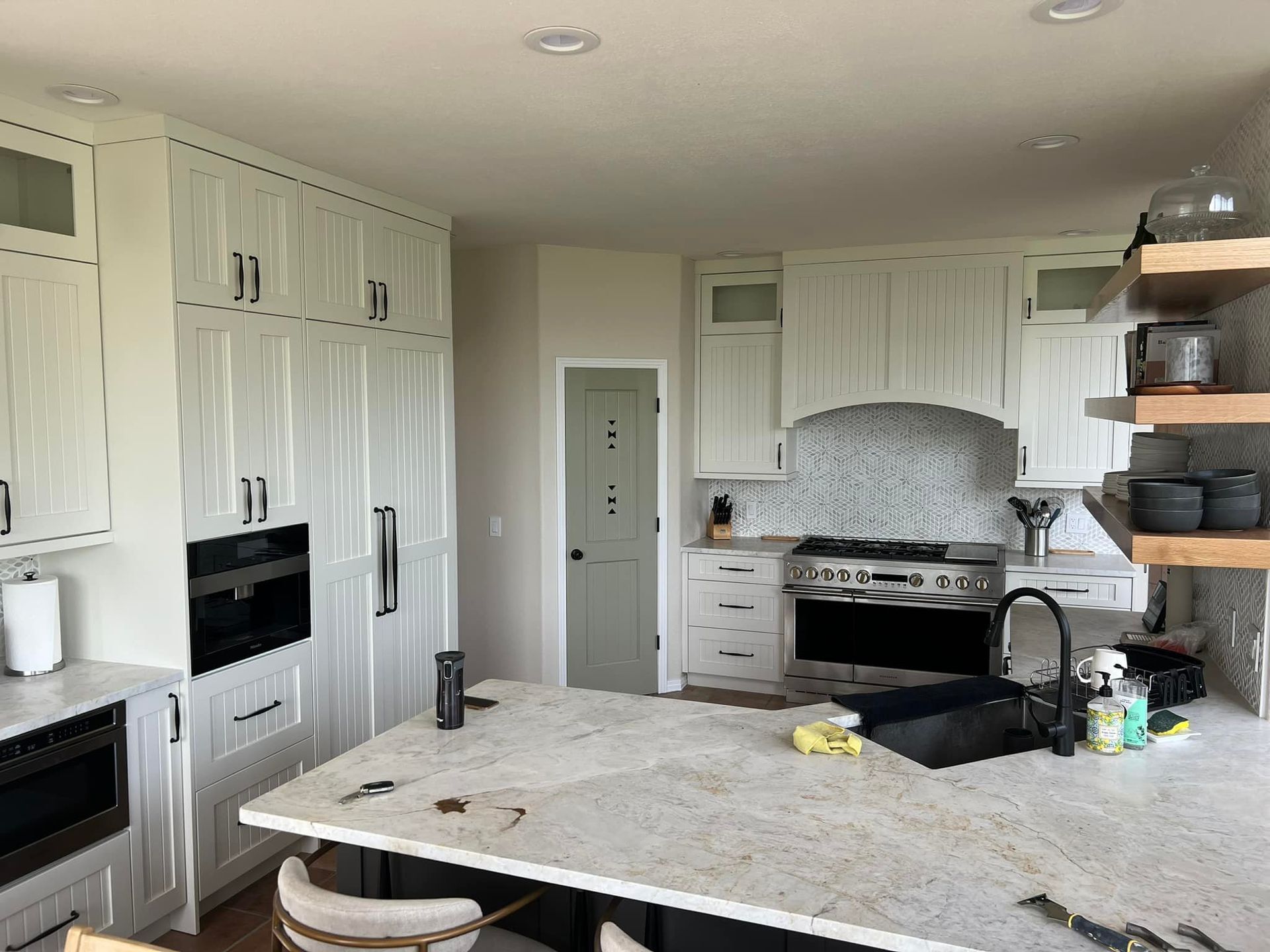 A kitchen with white cabinets and granite counter tops