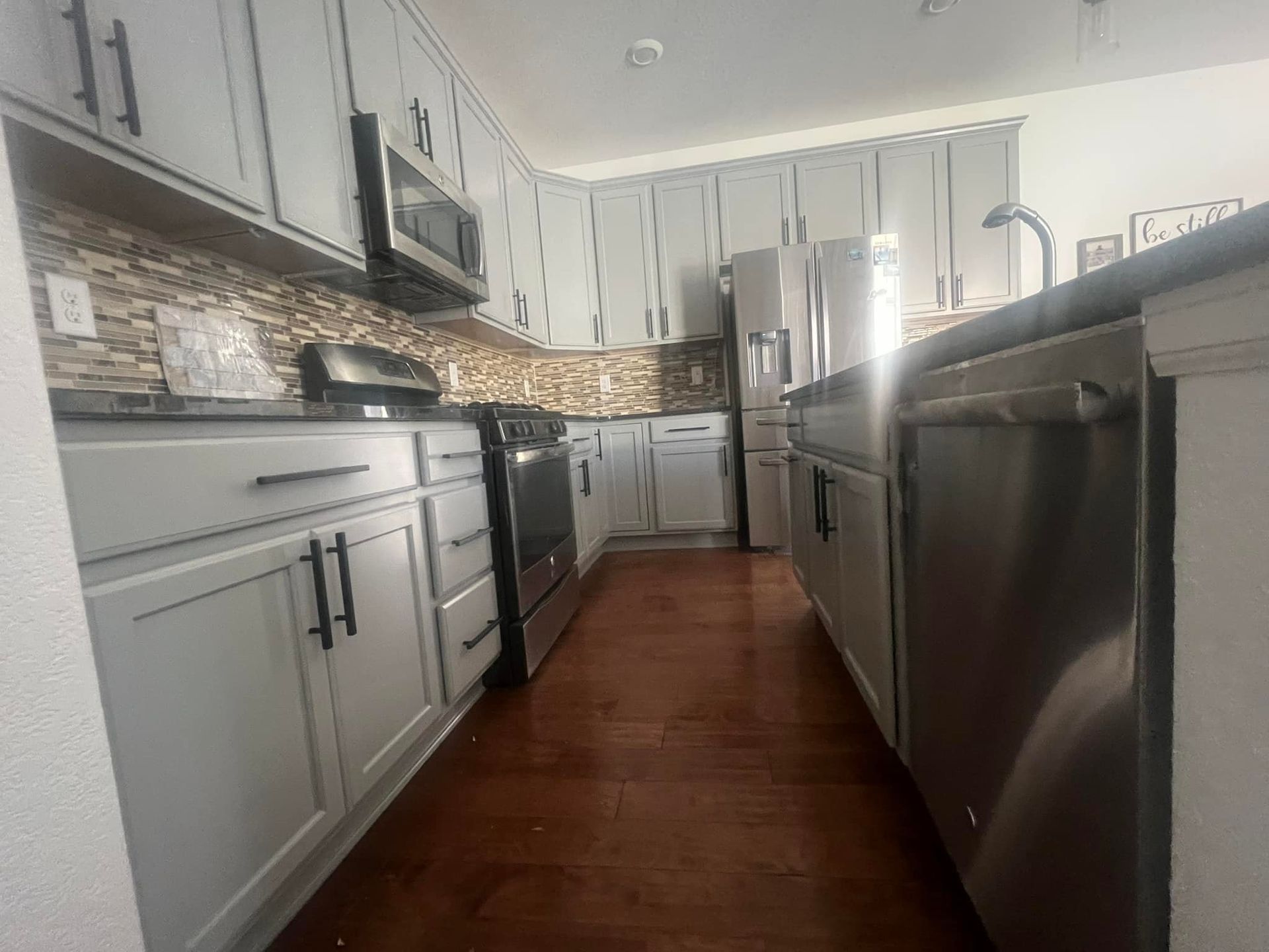A kitchen with stainless steel appliances and white cabinets.