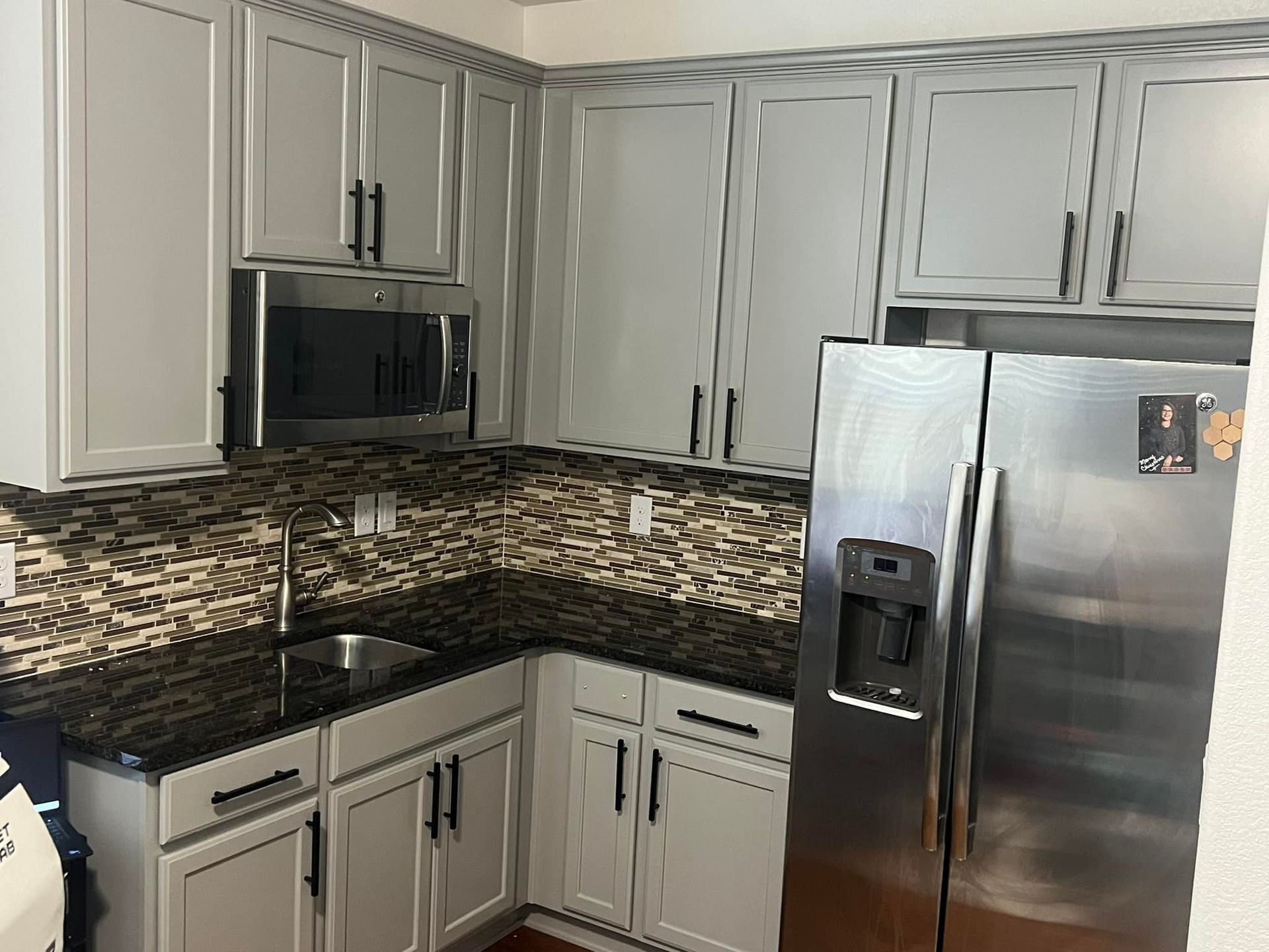 A kitchen with stainless steel appliances and white cabinets