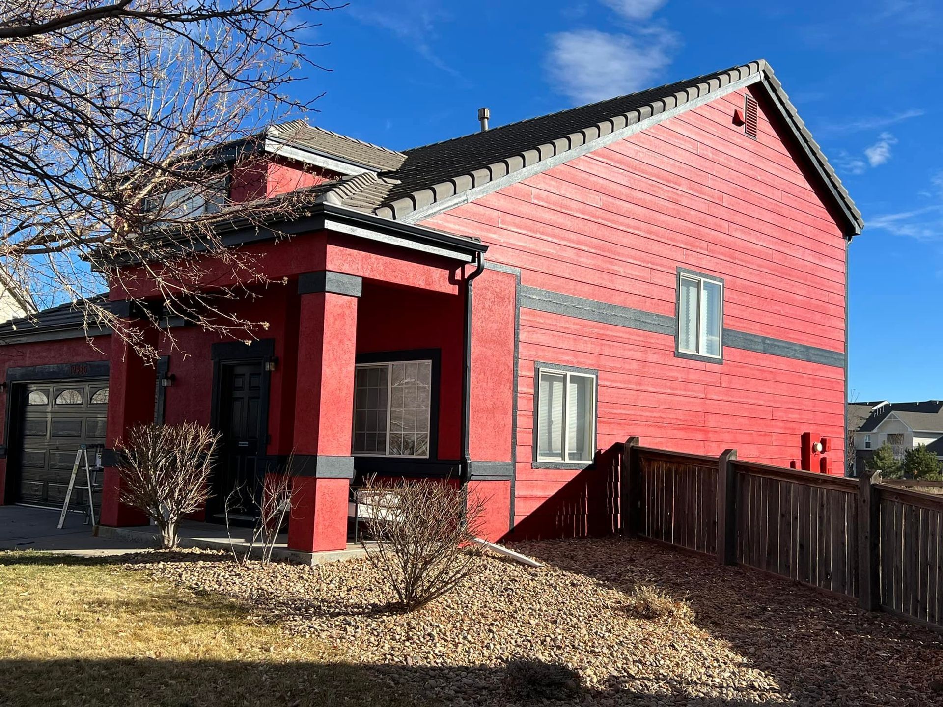 A red house with a fence in front of it