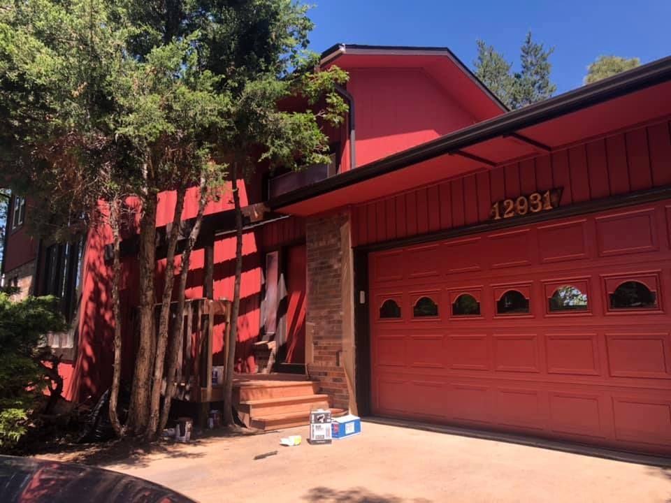 A red house with a red garage door and a red roof.