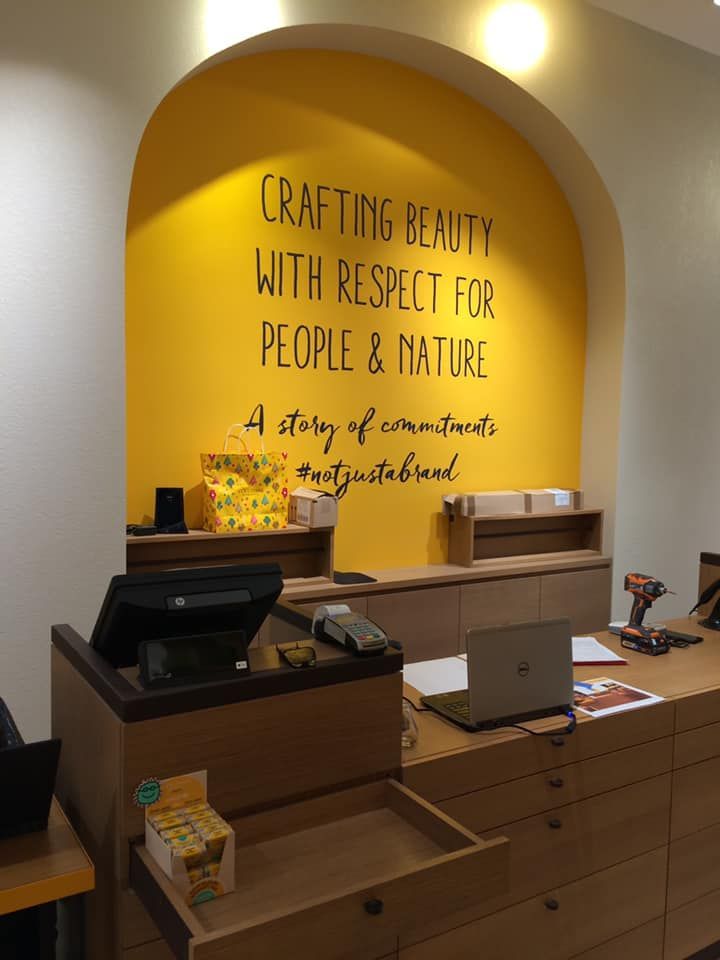 A yellow wall with a sign that says crafting beauty with respect for people and nature