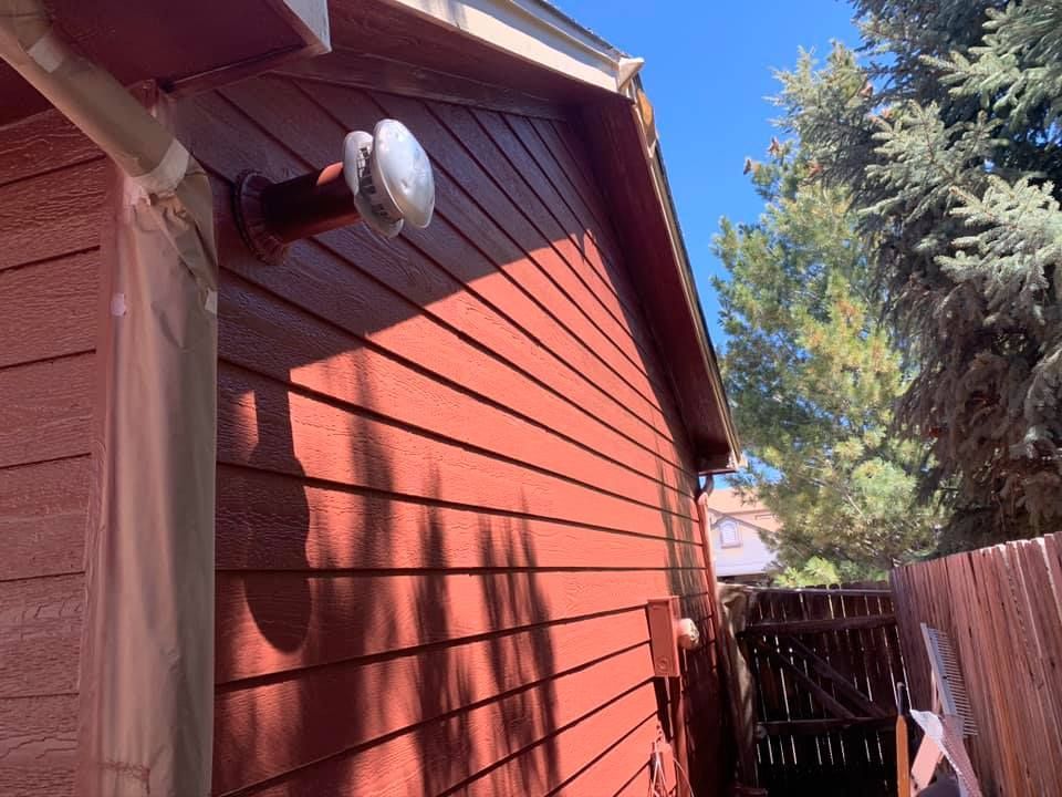 A red house with a light on the side of it.