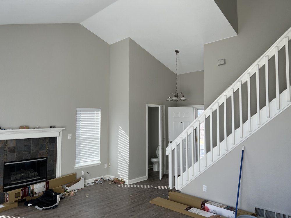 An empty living room with a fireplace and stairs