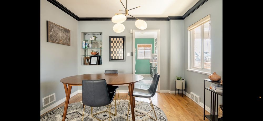 A dining room with a table and chairs and a rug.