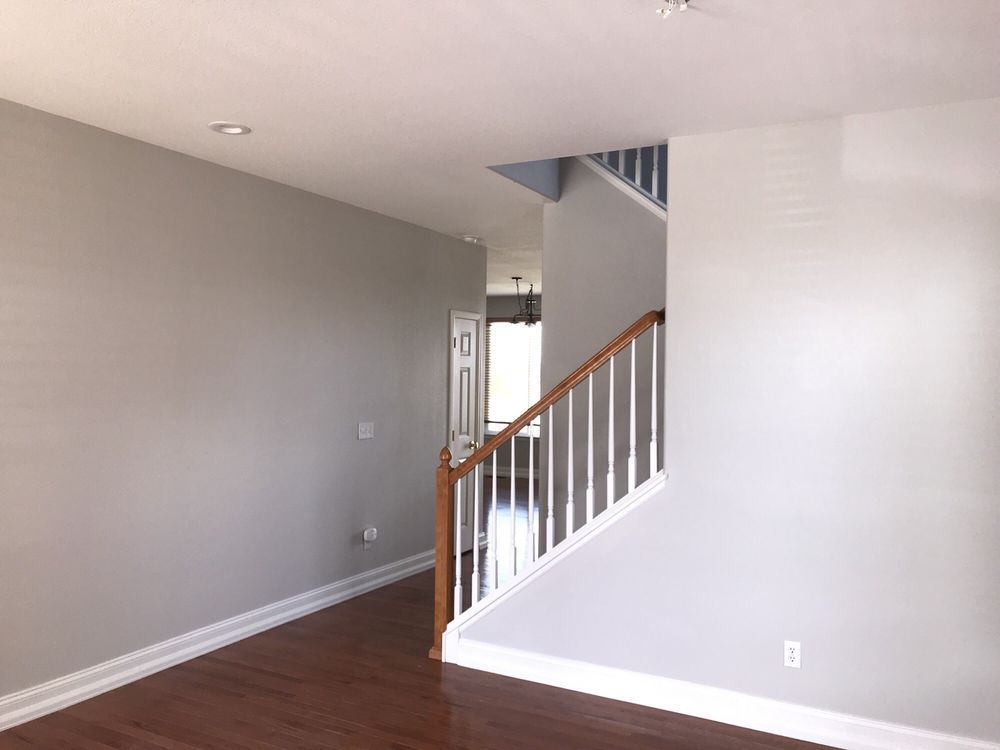 An empty living room with stairs leading up to the second floor