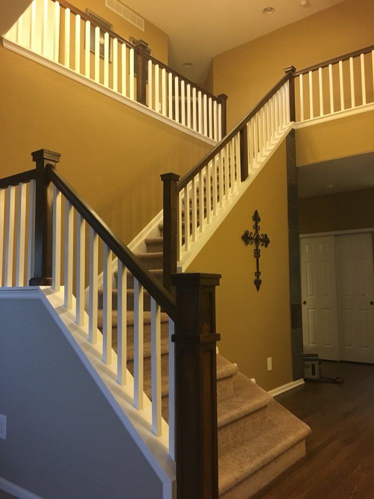 A staircase with white railings and a cross on the wall