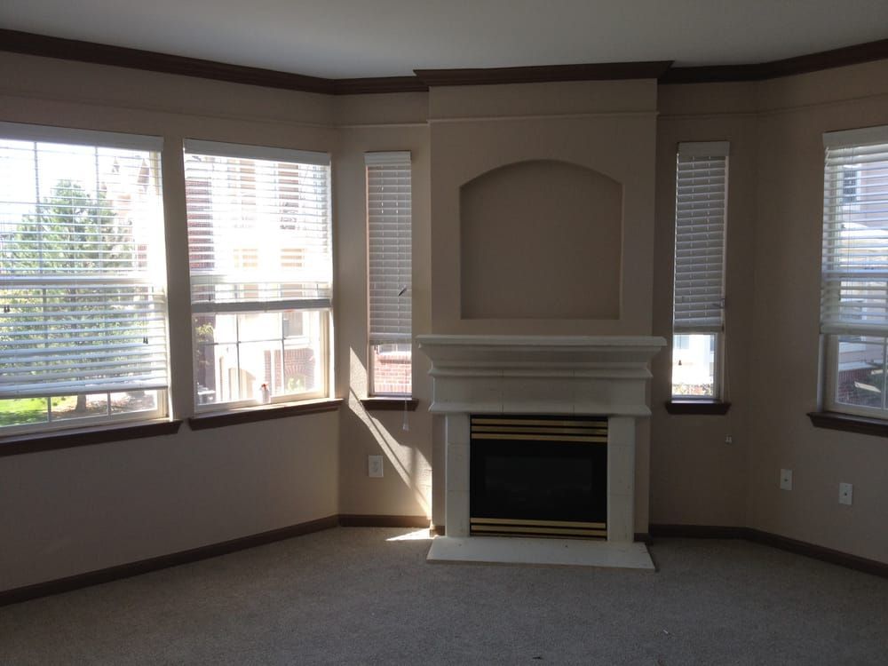 A living room with a fireplace and lots of windows
