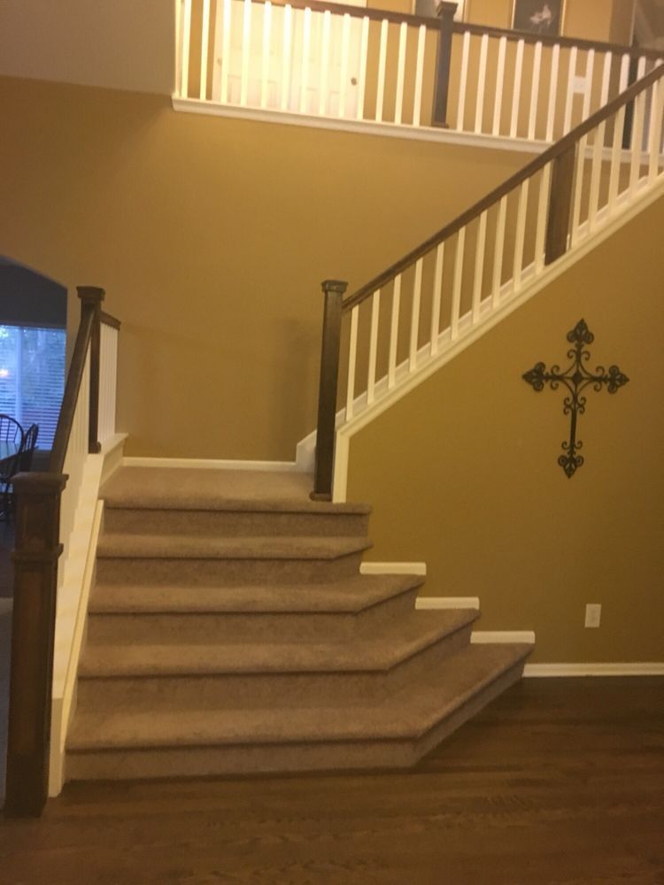 A staircase with a cross on the wall above it
