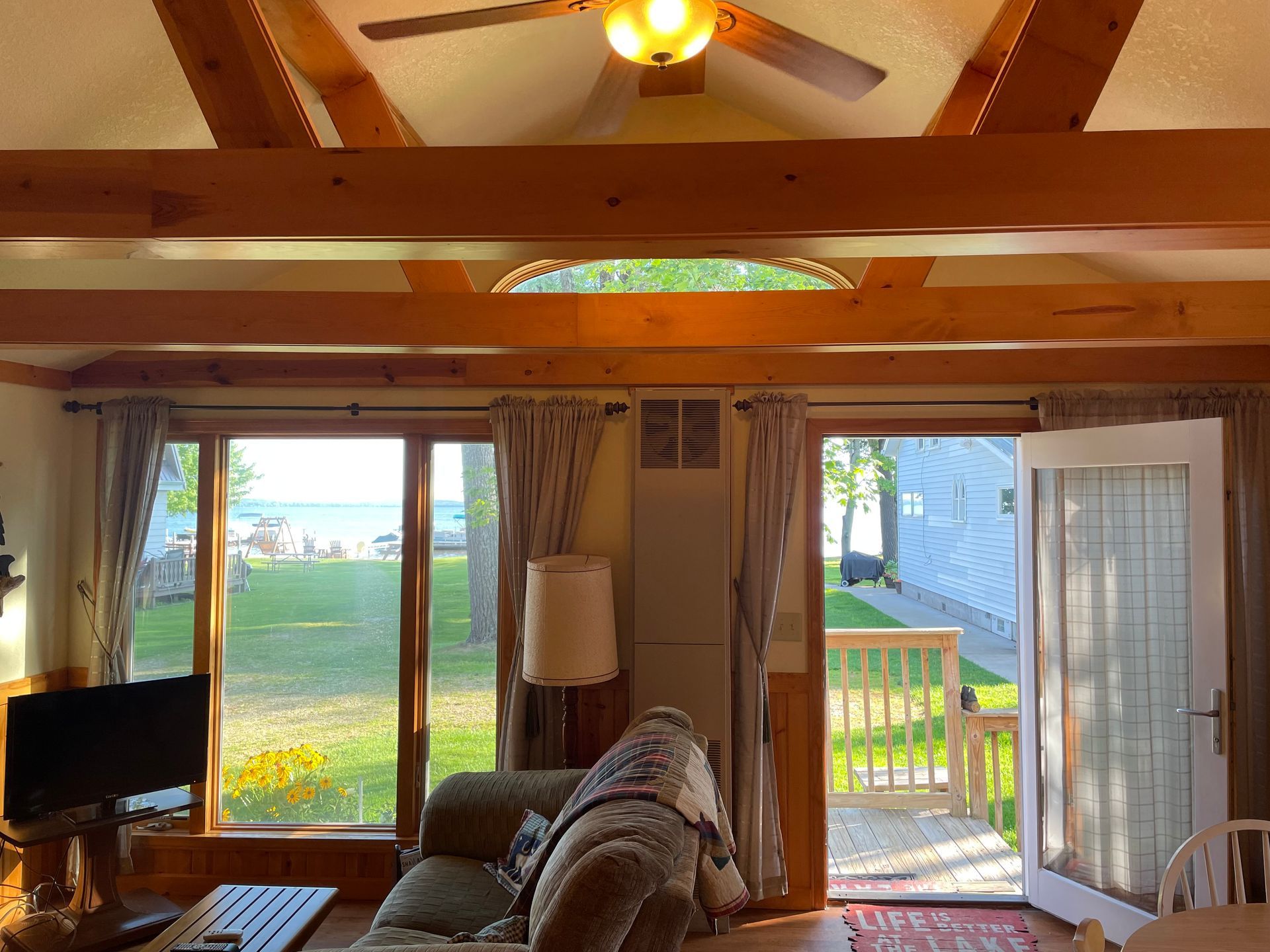 A living room with a lot of windows and a ceiling fan.