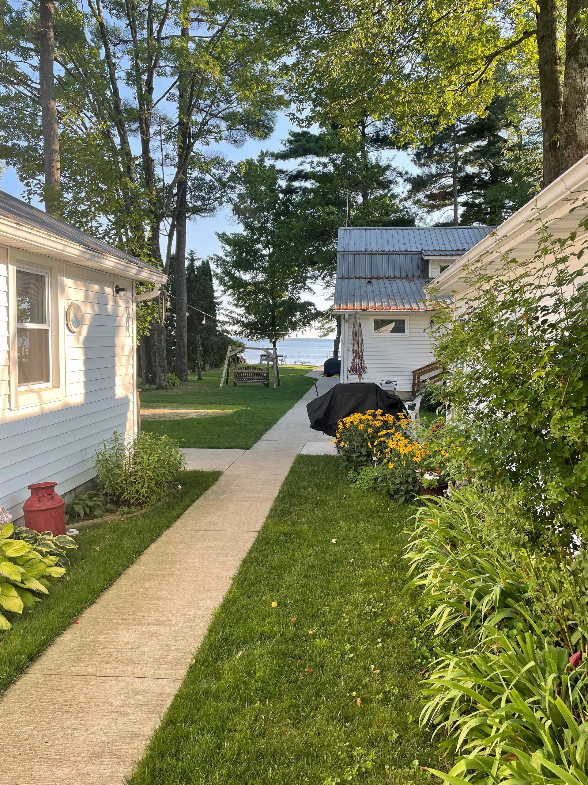 There is a walkway between two houses with a view of the lake.