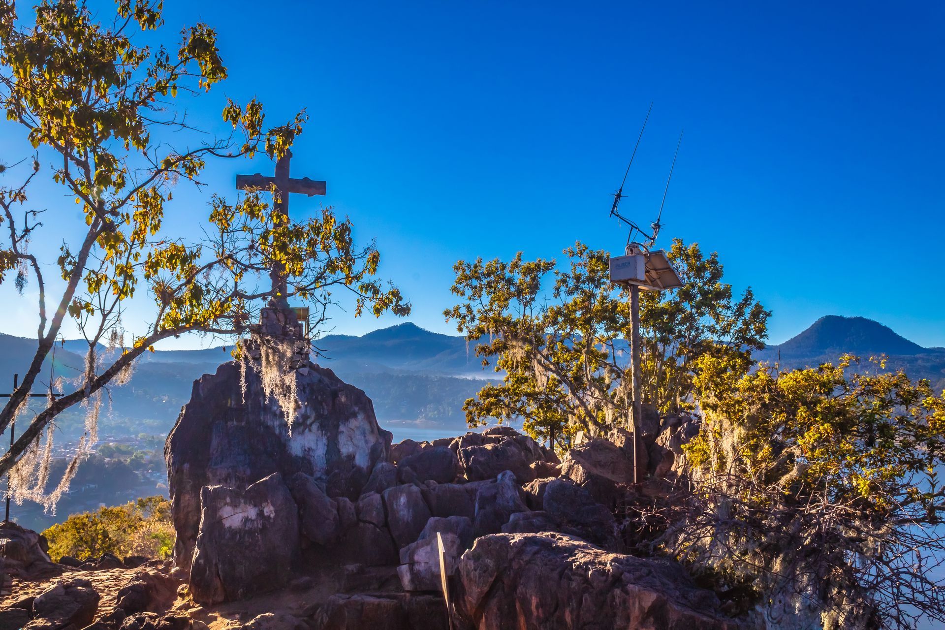 A cross is sitting on top of a rocky hill.