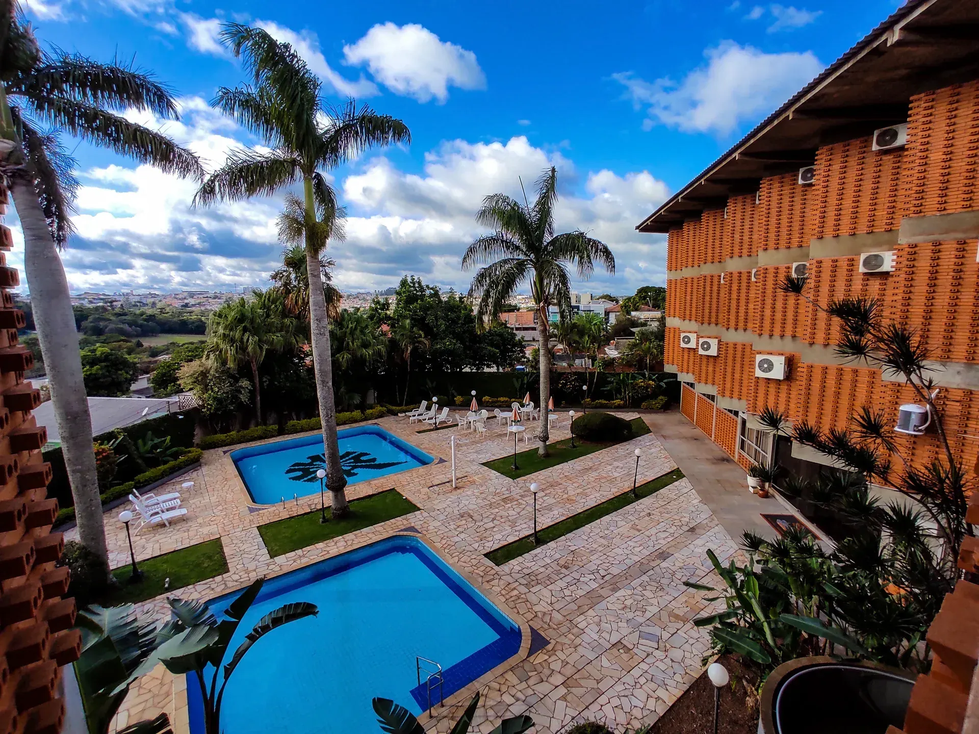 Piscina iluminada à noite com seções circulares. Luzes azuis e árvores.