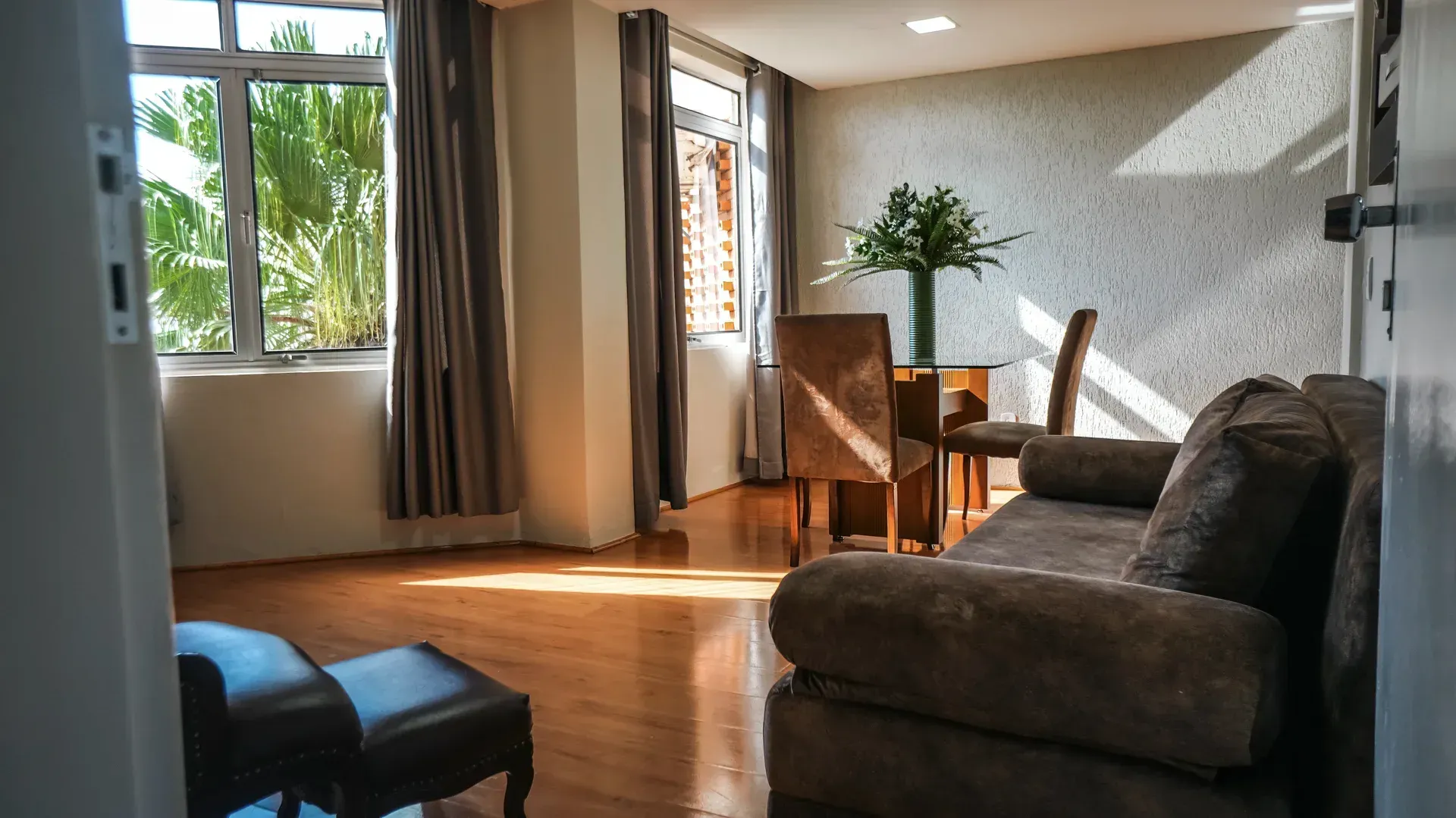 Interior de sauna de madeira com bancos, toalhas e porta.