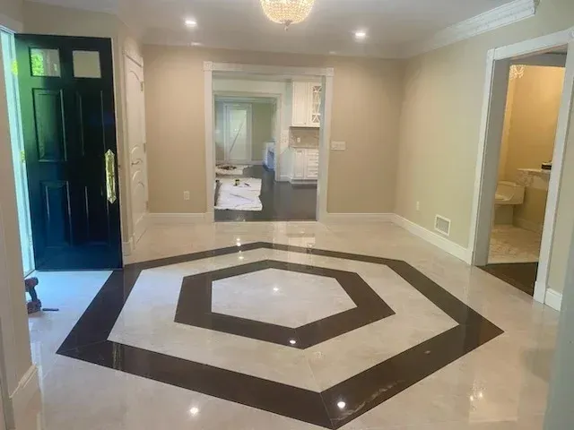 Entryway with octagonal tile design. Black door, beige walls, and doorways leading to other rooms.