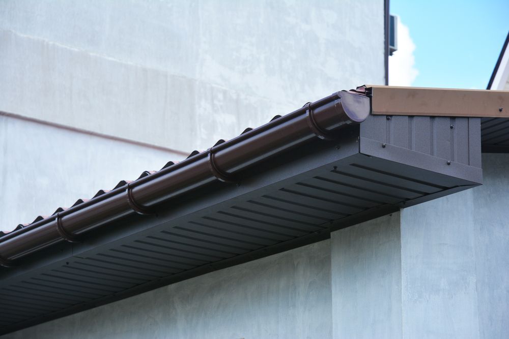A close up of a brown gutter on the side of a building.