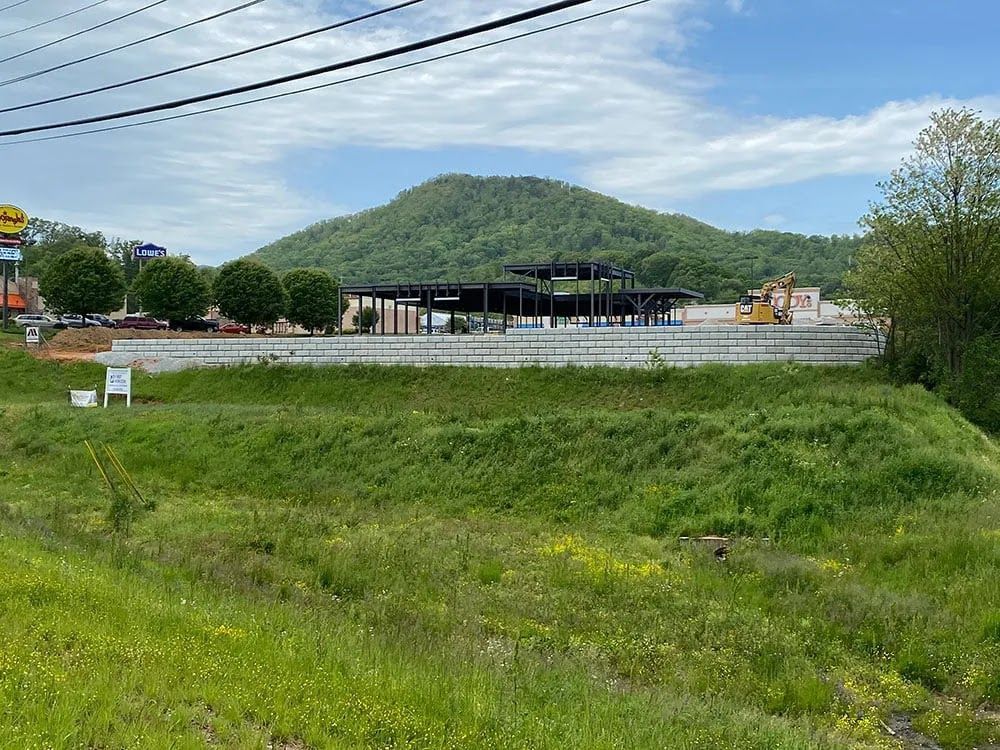 A large grassy field with a mountain in the background.