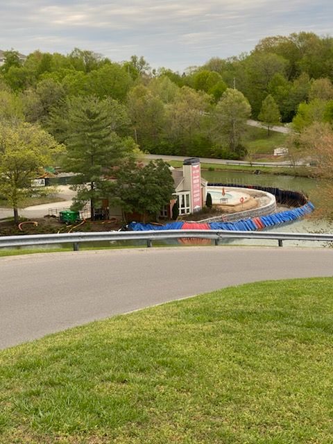 A road going through a park with a building in the background.