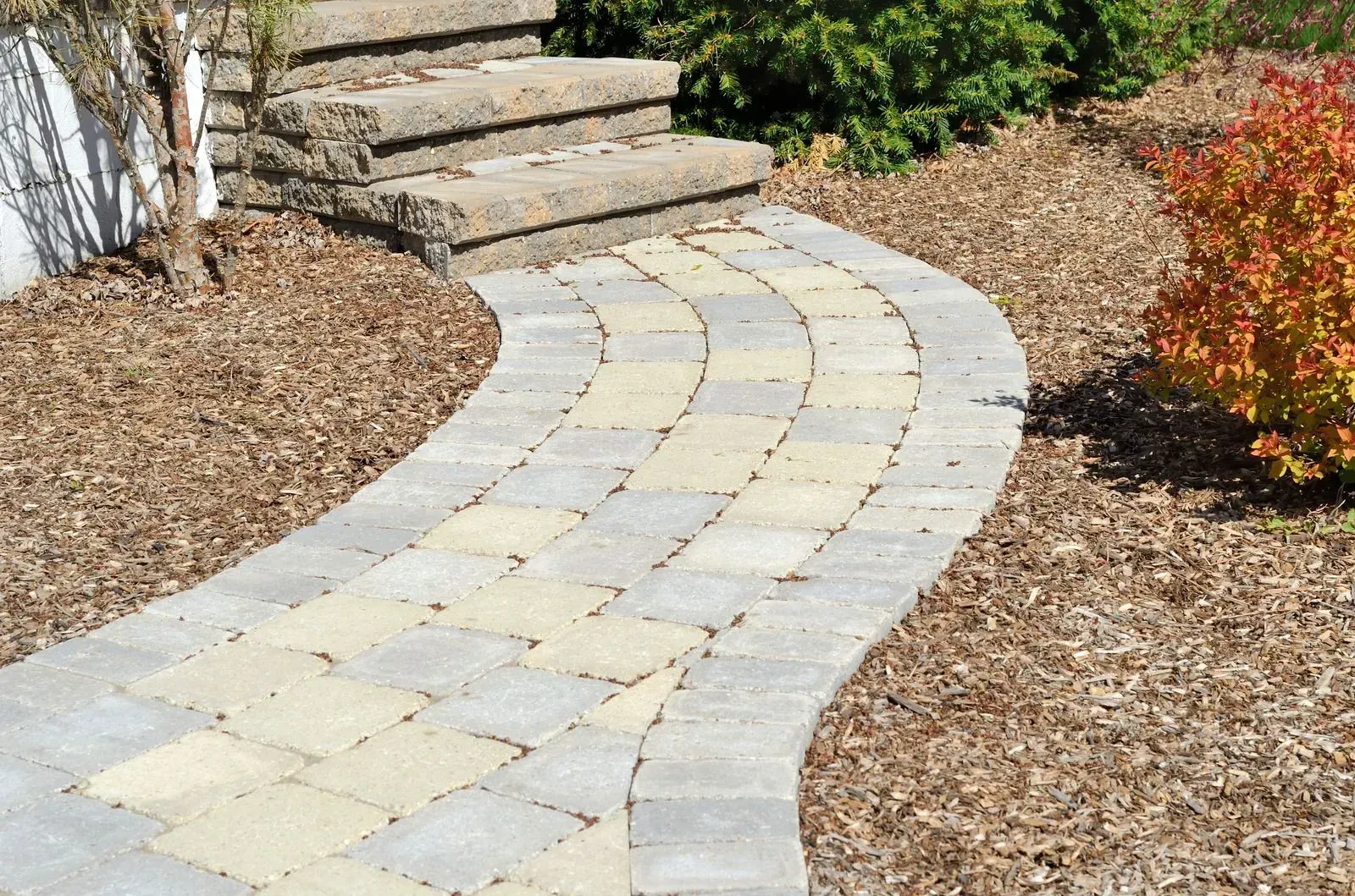 A brick walkway with stairs on the side of it