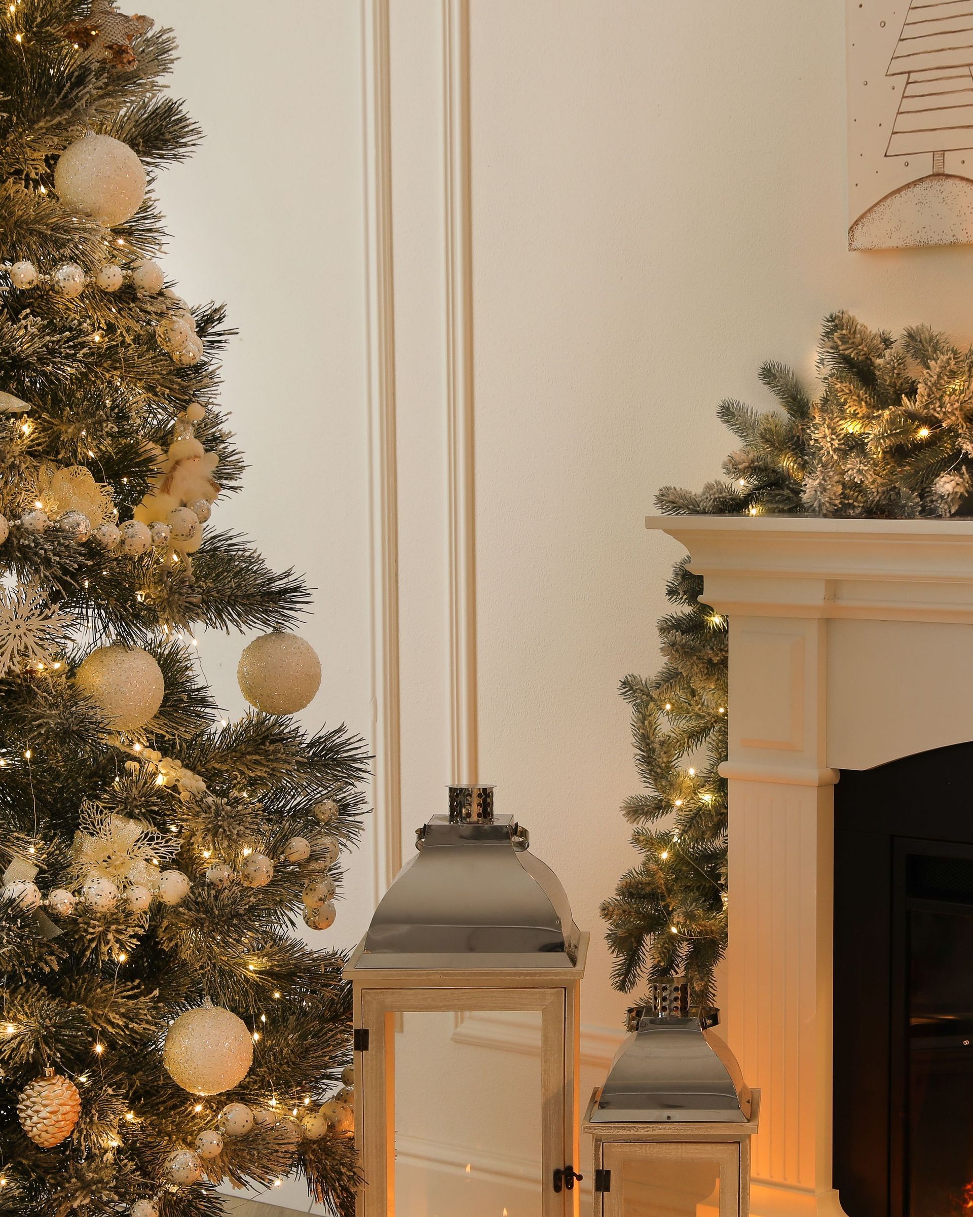 A fireplace with a christmas tree and lanterns in front of it