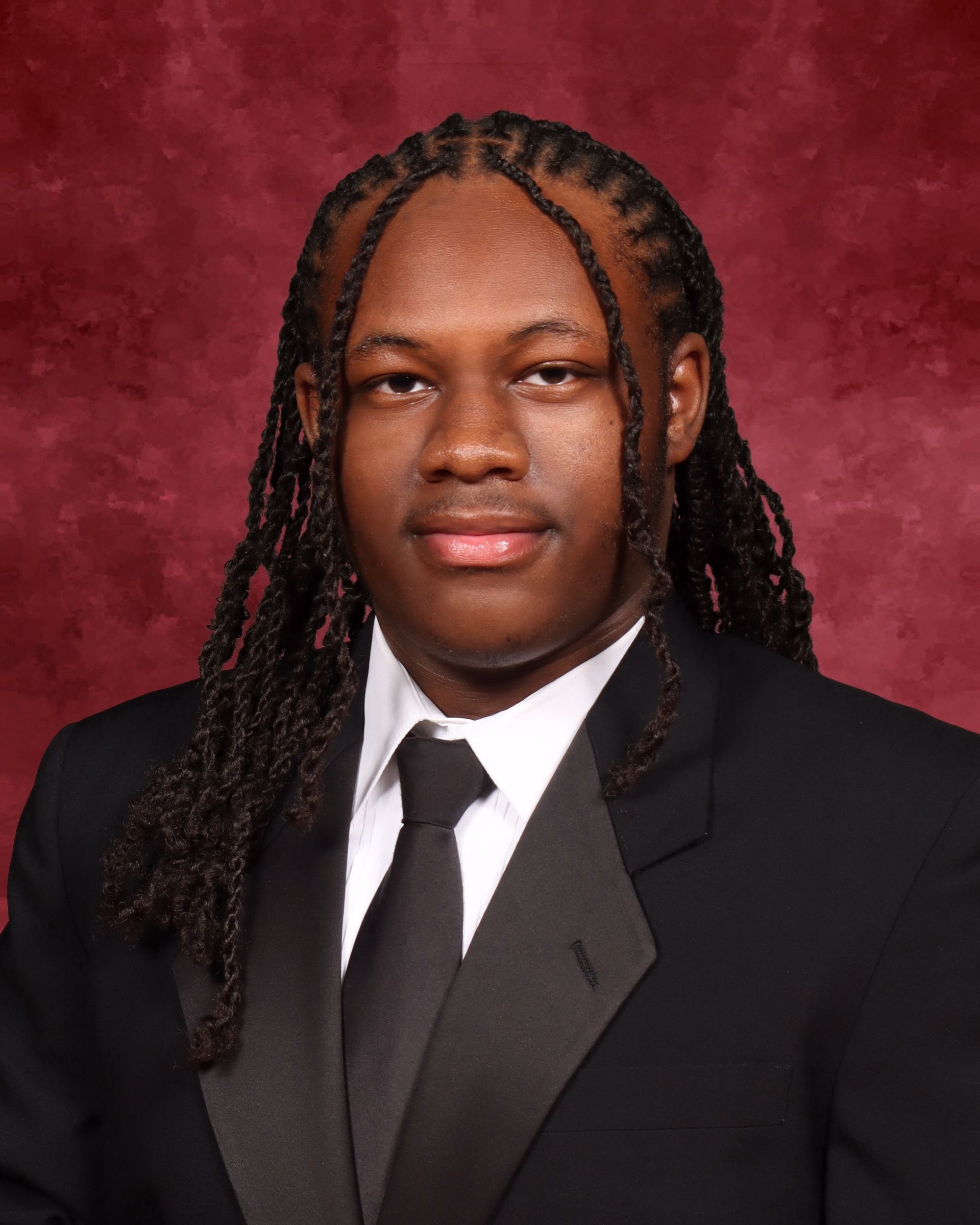 A man with dreadlocks is wearing a suit and tie