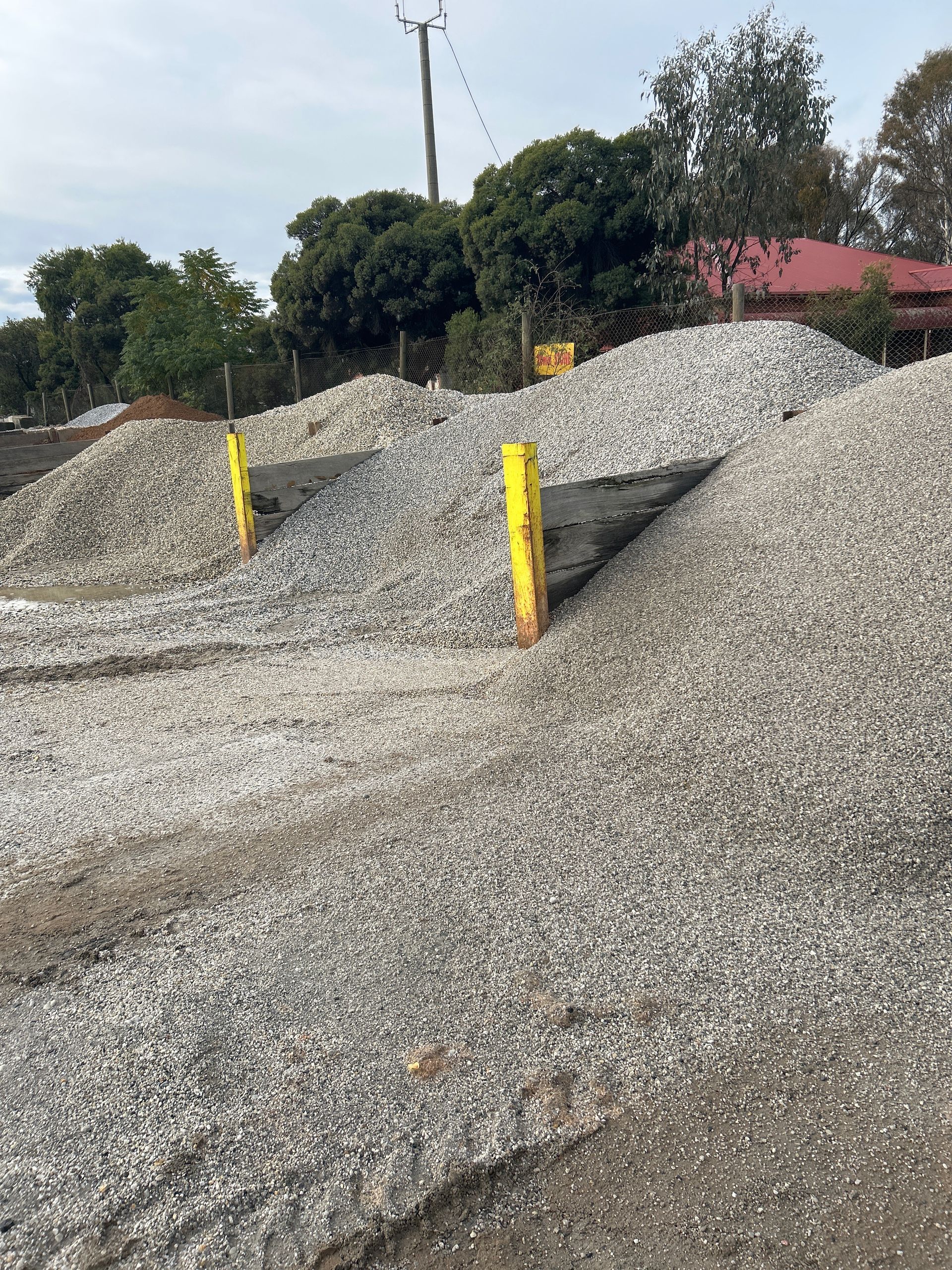 A Machine is Sitting on Top of a Pile of Rocks in a Quarry — Wodonga Sand & Soil in Wodonga, VIC
