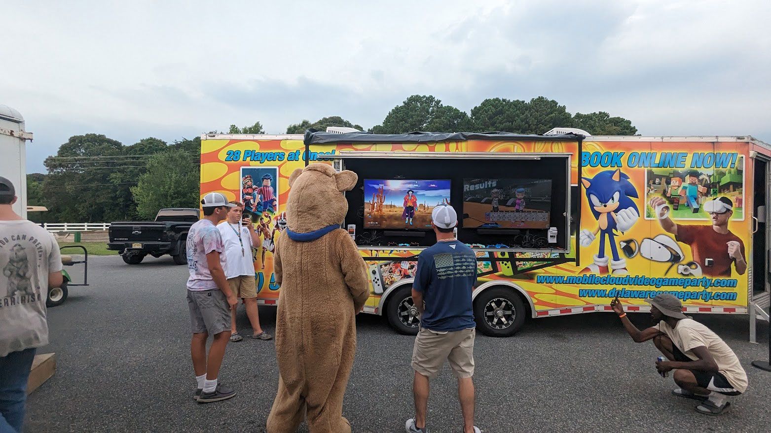 A mobile video game trailer featuring Sonic the Hedgehog graphics, with people and a mascot standing outside playing.