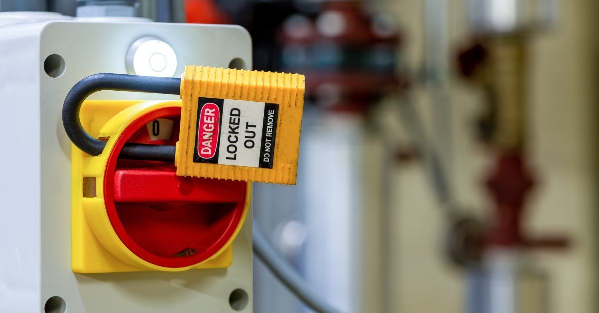 A yellow padlock on a large yellow industrial switch reads