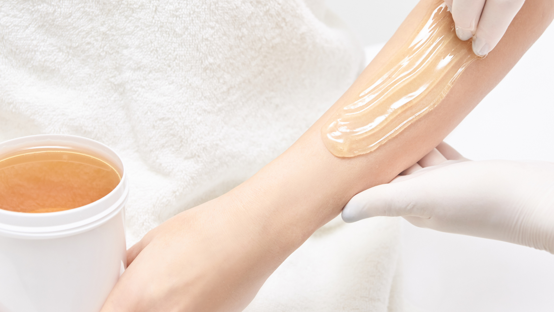 A woman is getting her arm waxed in a beauty salon.