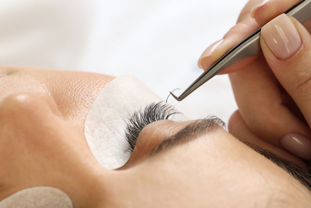 A woman is getting her eyelashes done at a beauty salon.