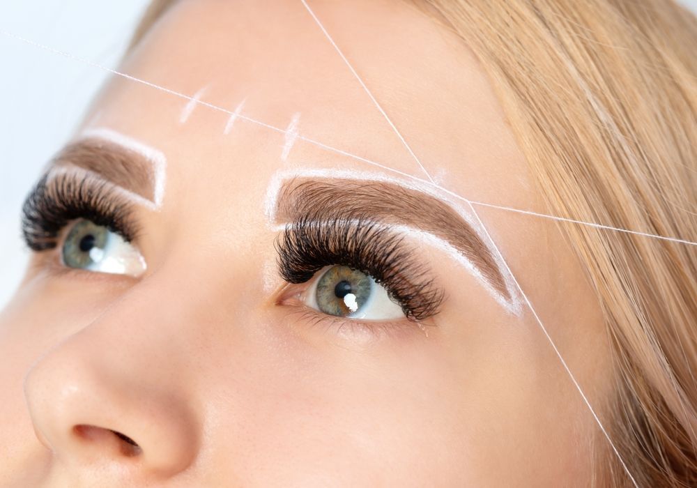 A close up of a woman 's face with a drawing of her eyebrows.