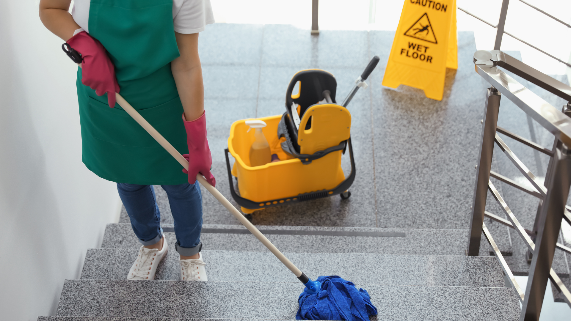 Person mopping stairs, yellow wet floor sign, cleaning supplies.