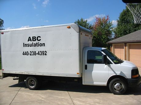 A white abc insulation truck is parked in a driveway