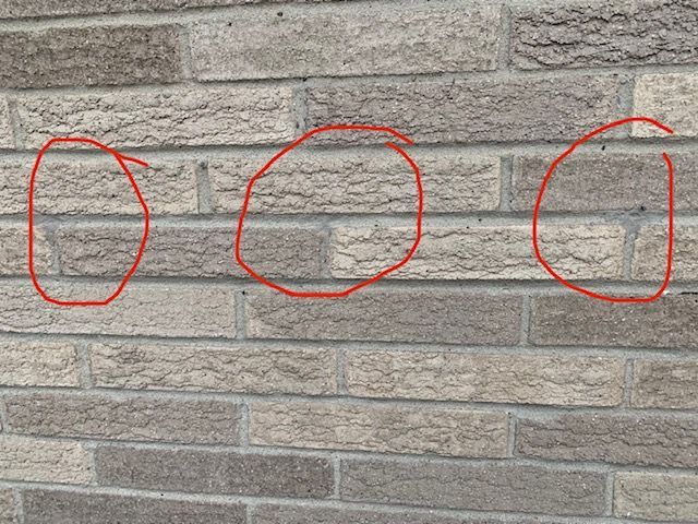A close up of a brick wall with circles drawn on it.