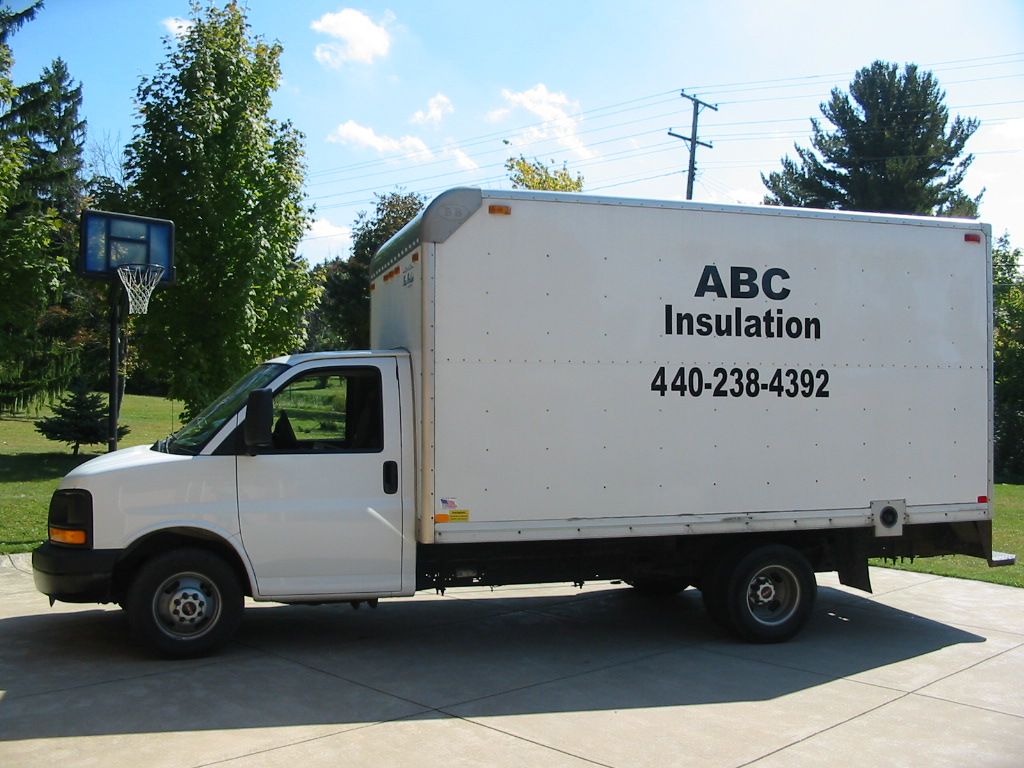 A white abc insulation truck is parked in a driveway