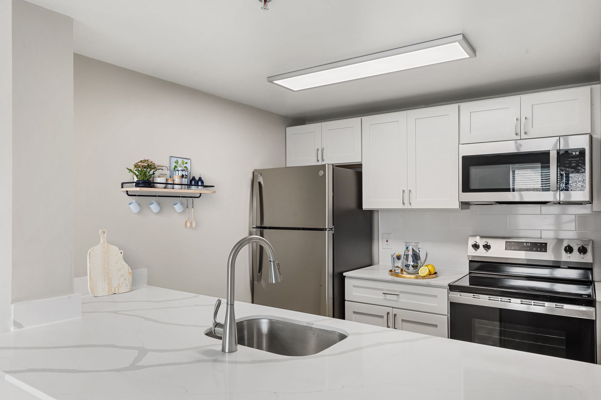 Kitchen with white cabinets, stainless steel appliances, and a light countertop.