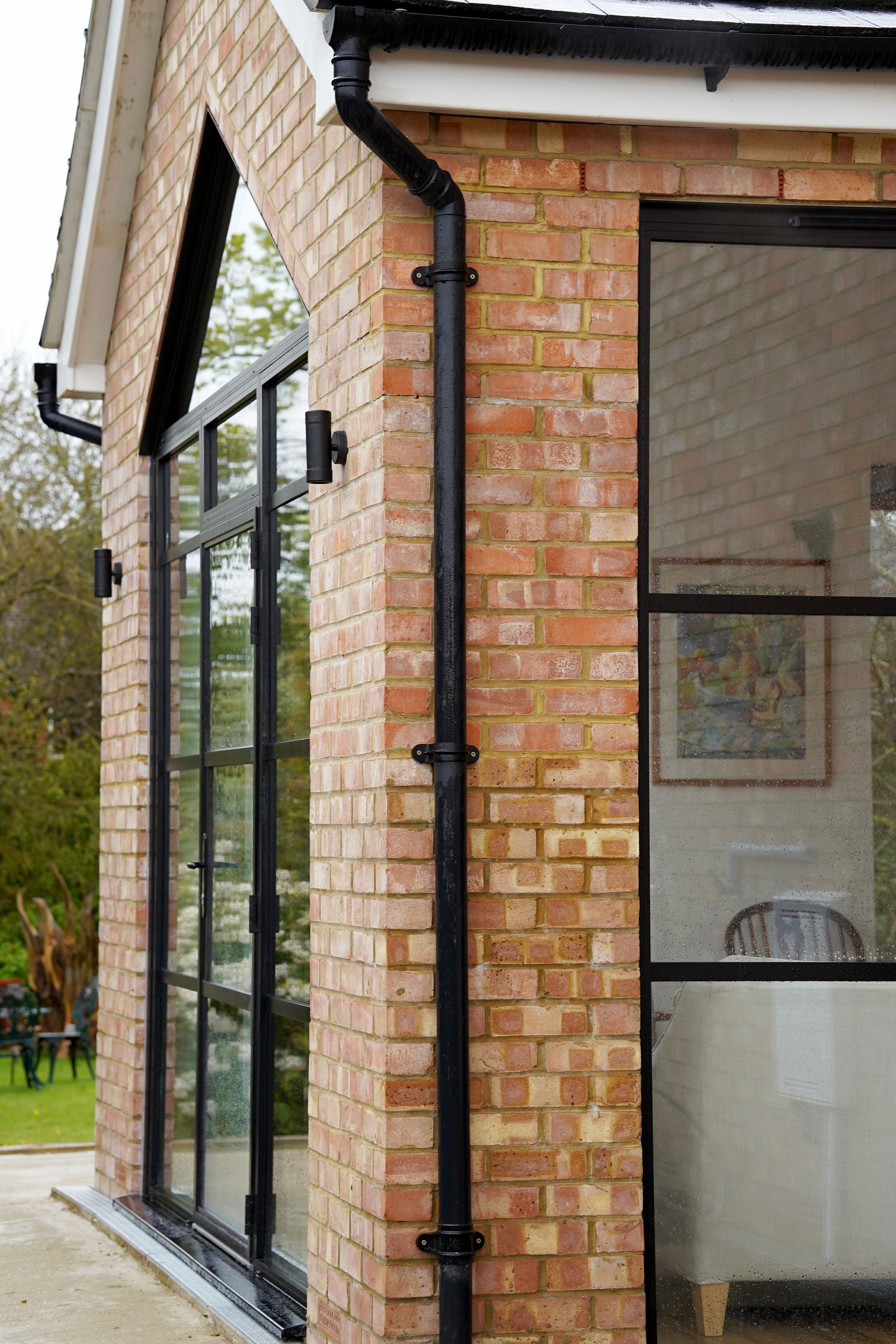 A house with a brick facade and a roof with two skylights  in a Large-Scale Retrofitting in East Sussex