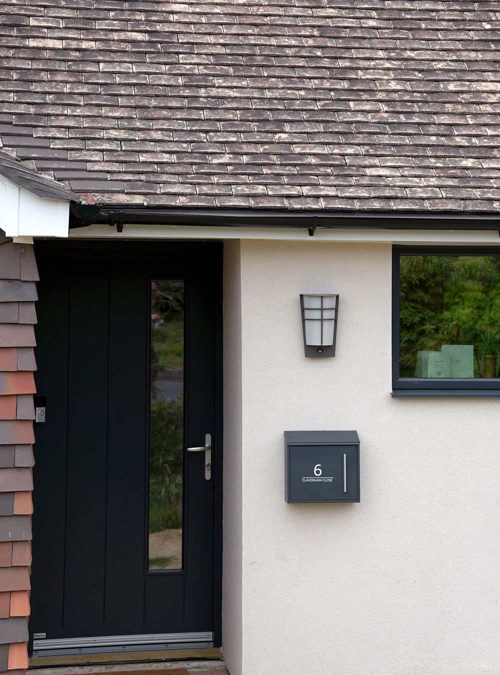 A white house with a black door and a mailbox  in a Retrofit Consultancy in East Sussex