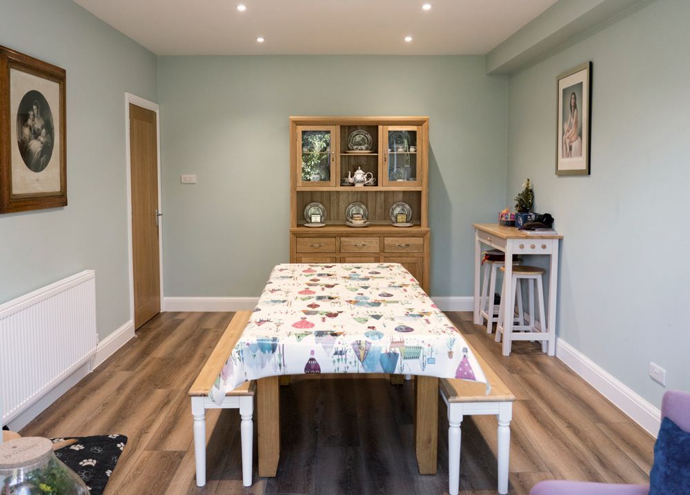 A dining room with a long table and benches in a Retrofit Consultancy in Hastings