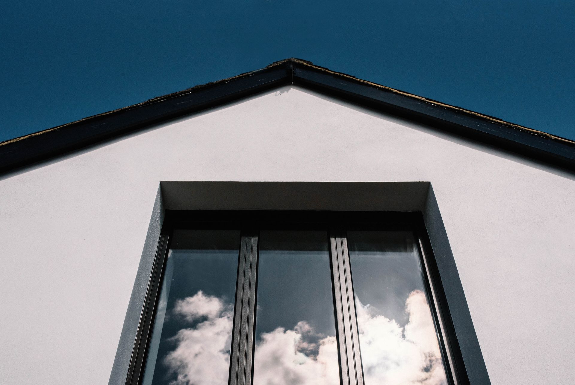A living room with a chair , bookshelf , and stairs in a Passivhaus New Builds in East Sussex